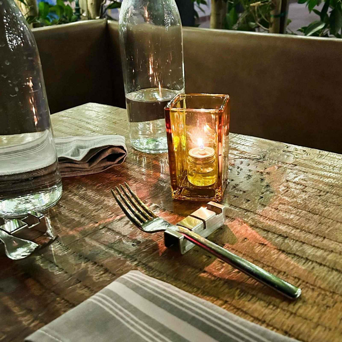Radiko 304 stainless steel flatware rest holding a fork on a restaurant table beside a candle and water bottles