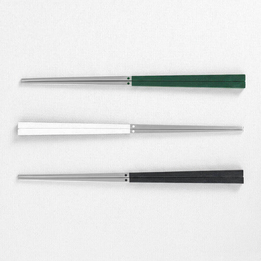 Three 316 stainless steel chopsticks with three different colored handles green, white and black on a white background