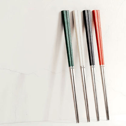 Radiko 316 stainless steel chopsticks with wood-grain handles in green, white, black, and red, leaning against a white wall