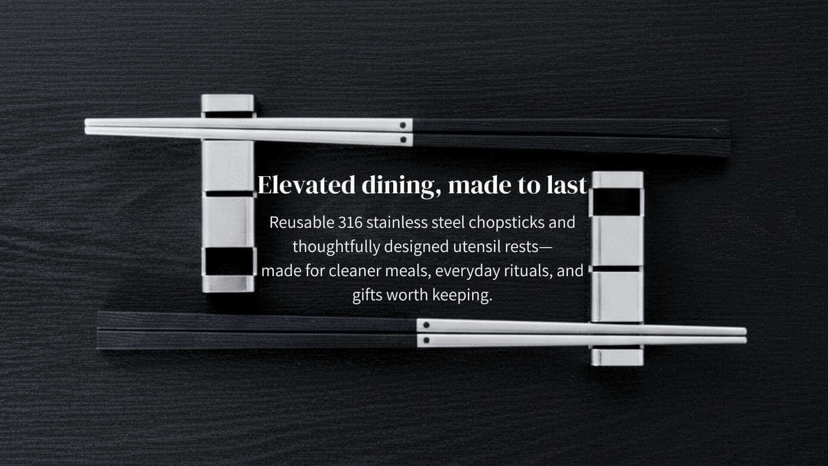 Premium 316 stainless steel chopsticks and luxury metal chopstick rests arranged symmetrically on a dark textured wood tabletop.