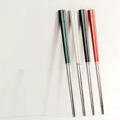 Radiko custom logo engraved 316 stainless steel chopsticks with wood-grain handles in green, white, black, and red, leaning against a white wall for weddings and corporate gifts