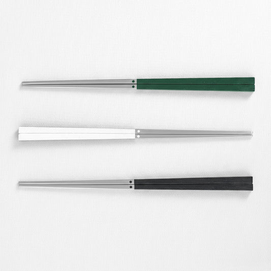 Three 316 stainless steel chopsticks with three different colored handles green, white and black on a white background